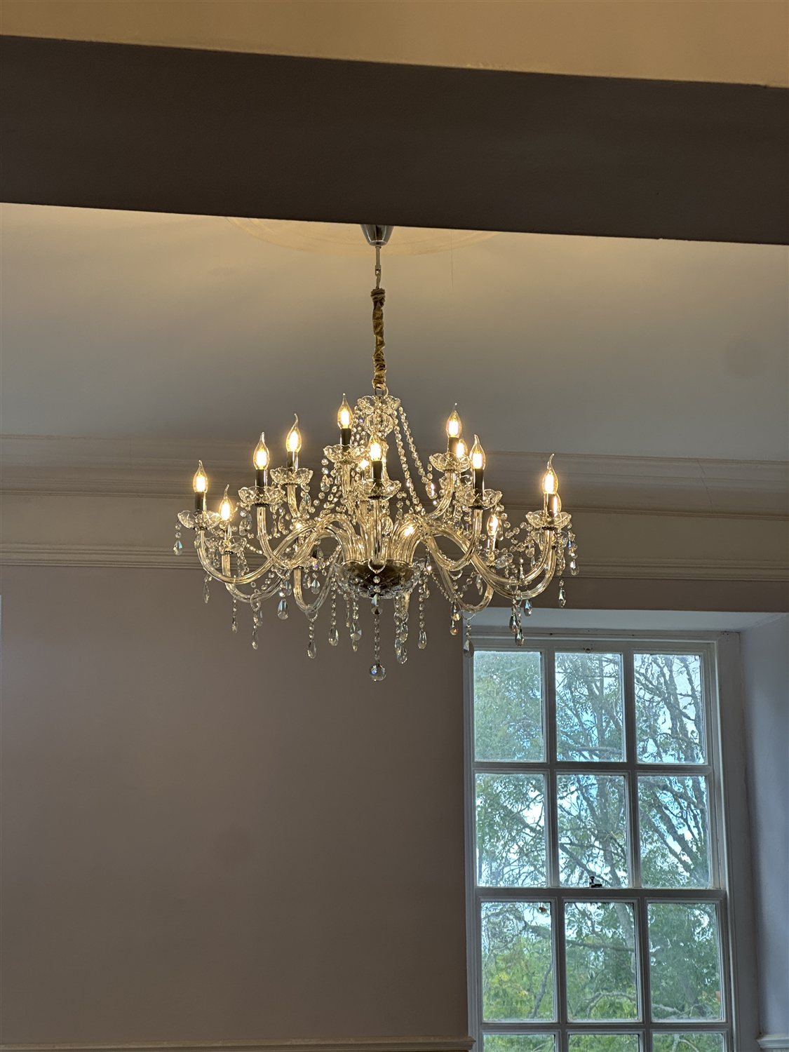 Crystal chandelier in the Ceremony Room beside a tall sash window