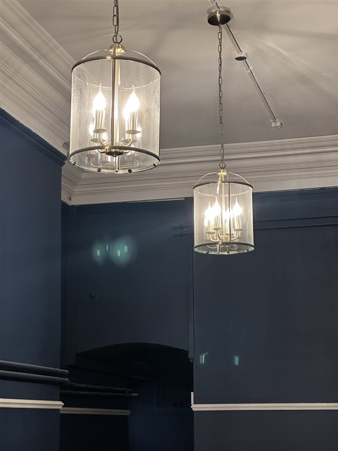 Glass lantern pendant lights against the Gallery's deep blue walls