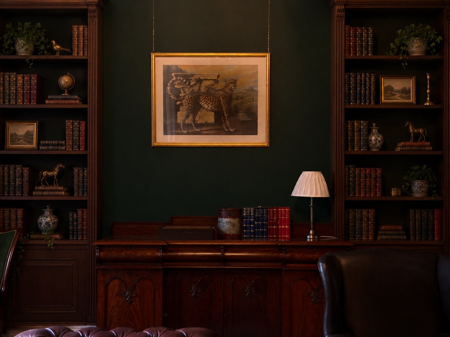 Built-in bookshelves either side of a framed painting and sideboard